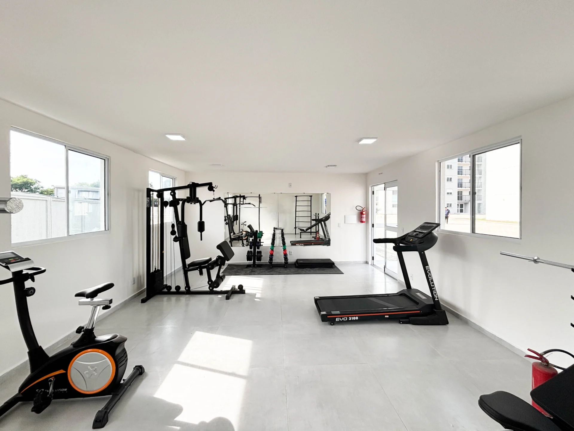 Foto ampla da academia equipada entregue no Residencial Capri, com esteira