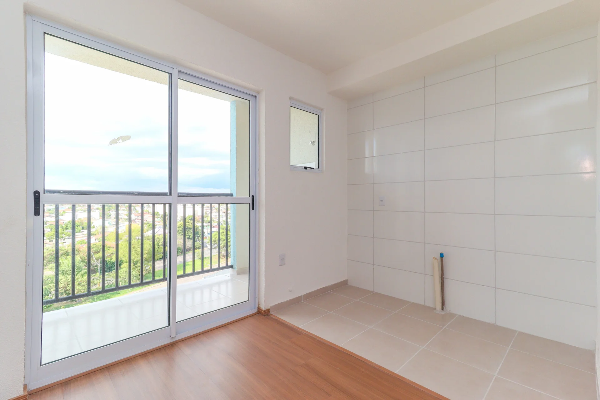 Foto da cozinha azulejada de apartamento entregue do Residencial Capri, com acesso à sacada