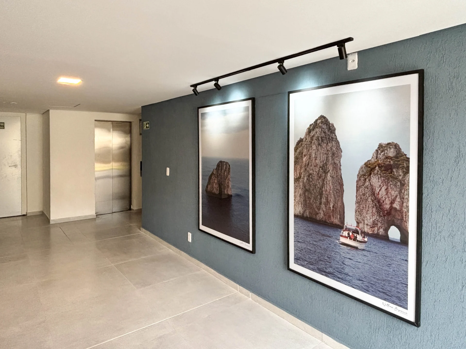 Foto do hall de entrada construído do Residencial Capri, com elevador e quadros
